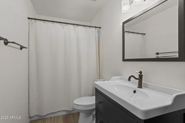 a bathroom with a sink mirror and toilet