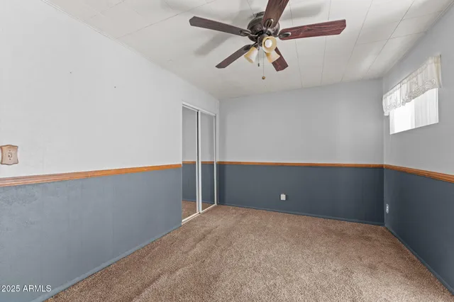 a view of a big room with a ceiling fan and window