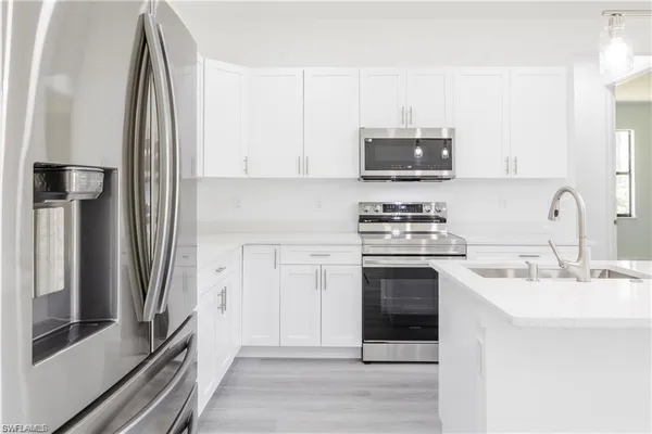 a kitchen with stainless steel appliances white cabinets and a sink
