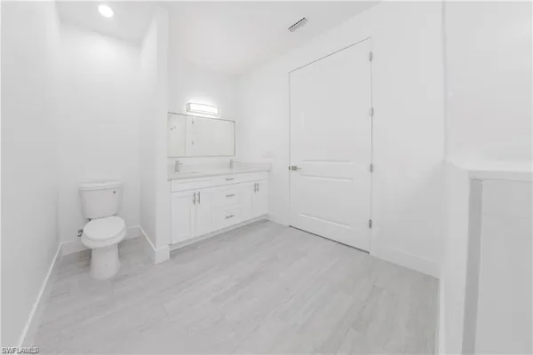 a spacious bathroom with 2 sink and a mirror