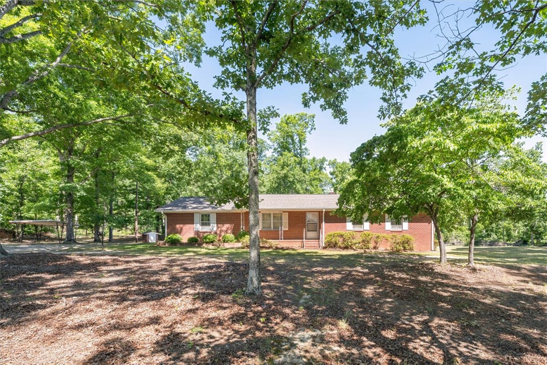 304 Shaw Road Honea Path, SC 29654 - Photo 38 of 39 This charming brick home is nestled among mature trees, offering a serene and private setting.
