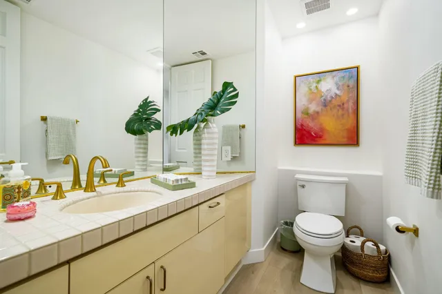 a bathroom with a toilet sink and mirror