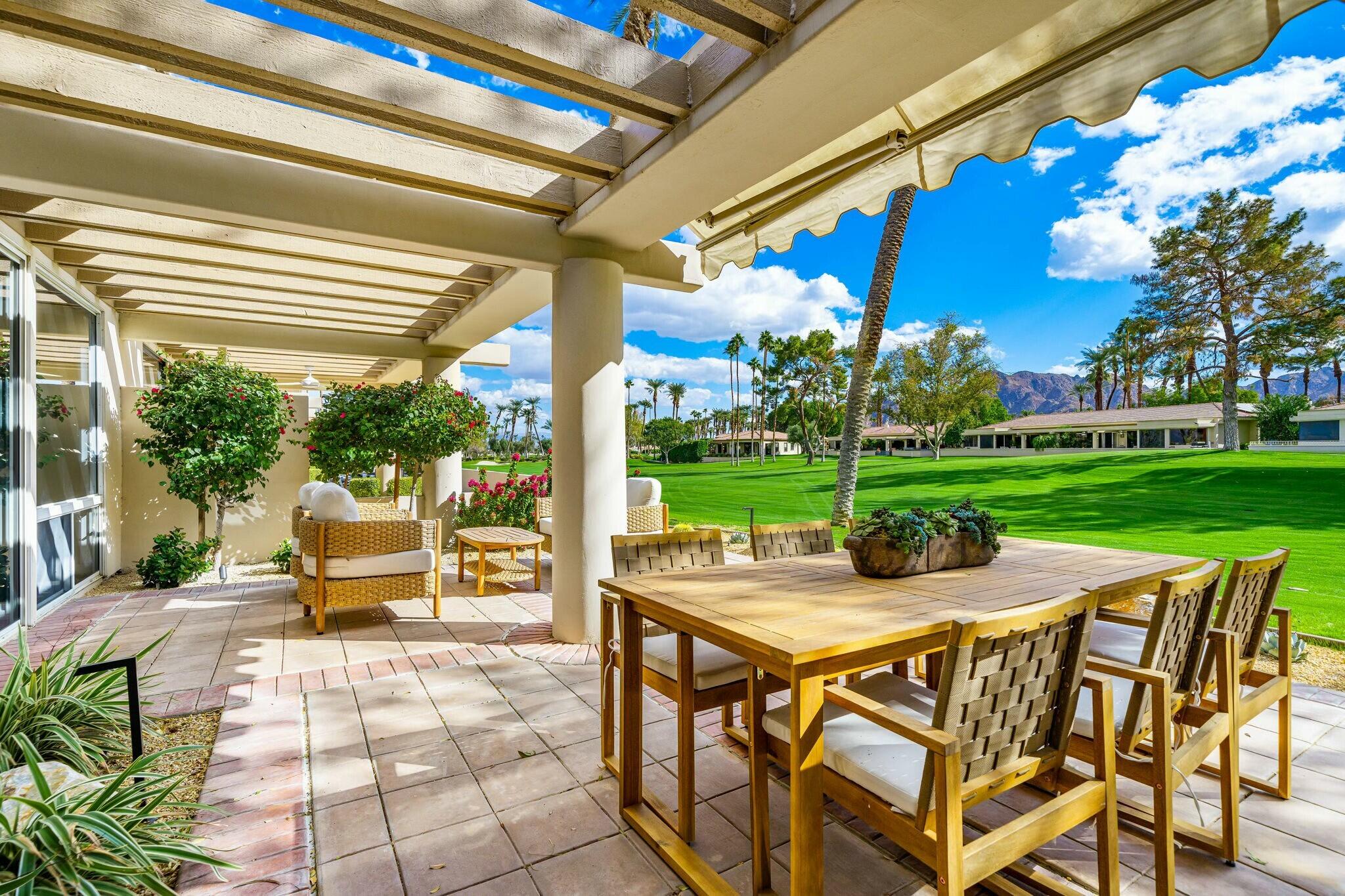 75405 Riviera Drive Indian Wells, CA 92210 - Photo 35 of 43 a view of a patio with a table chairs and a backyard