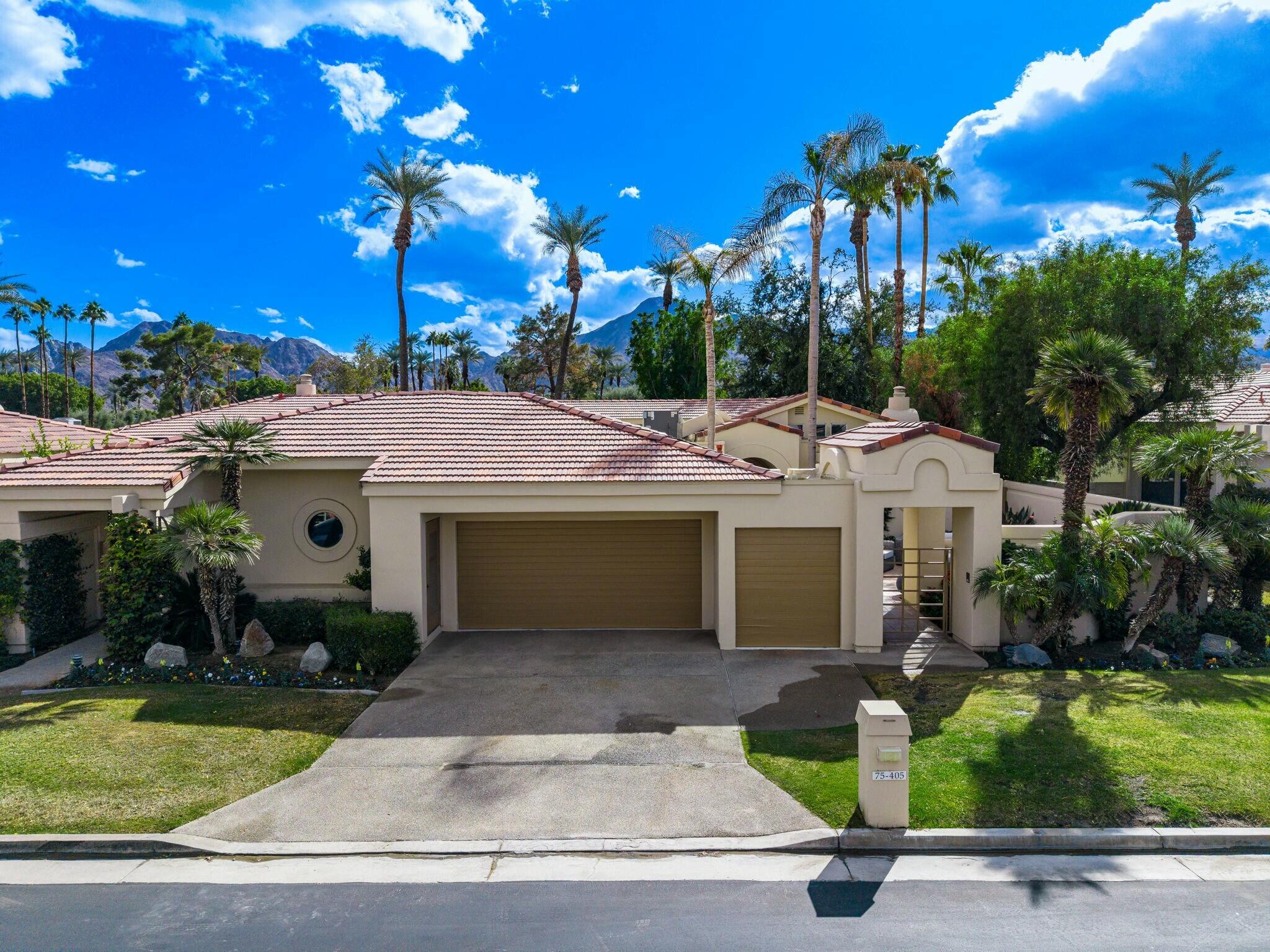 75405 Riviera Drive Indian Wells, CA 92210 - Photo 37 of 43 a view of a white house with a yard and potted plants