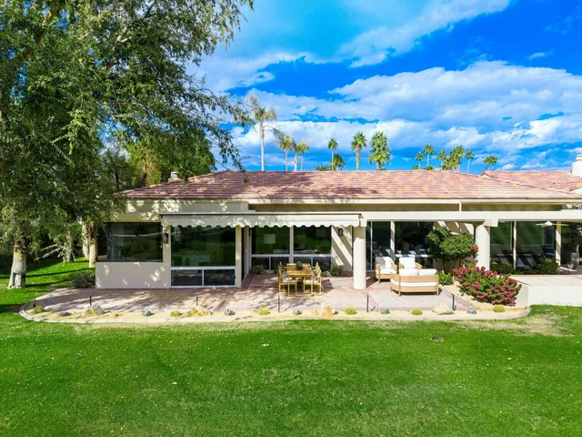 a view of a patio with a table and chairs under an umbrella