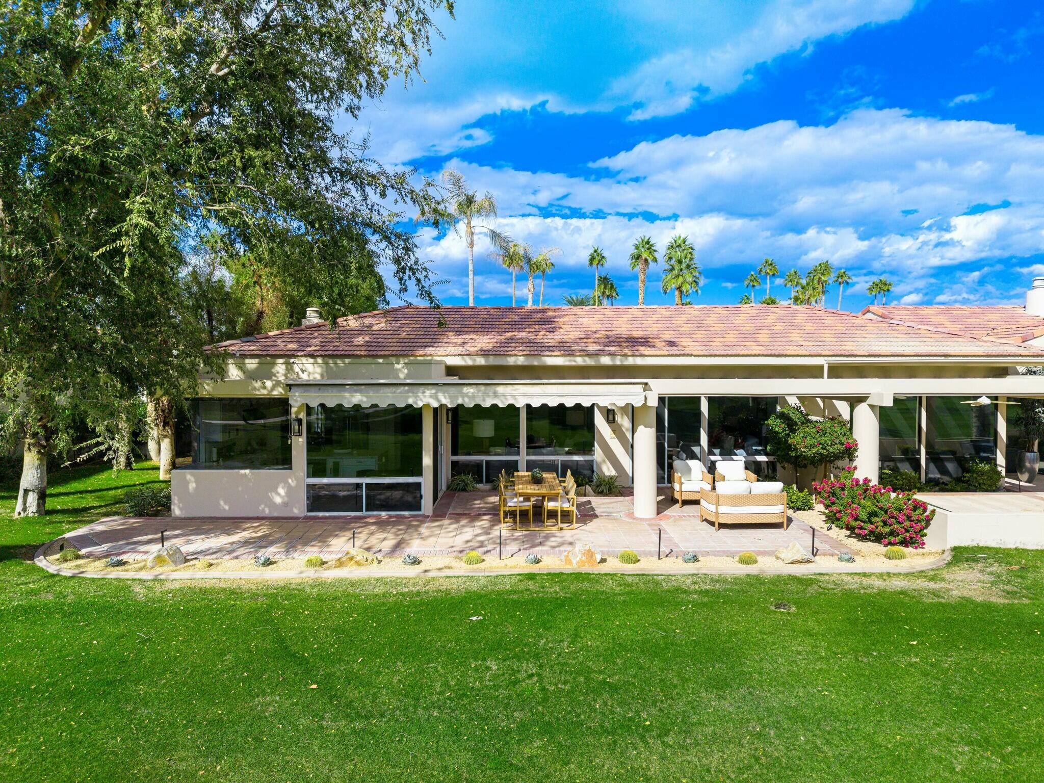 75405 Riviera Drive Indian Wells, CA 92210 - Photo 7 of 43 a view of a patio with a table and chairs under an umbrella