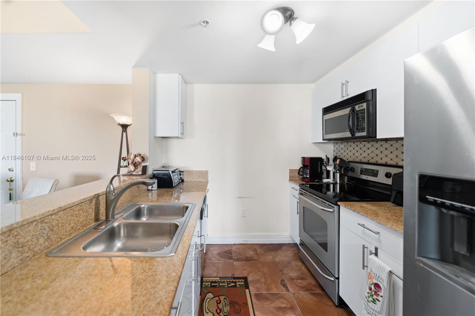 117 Northwest 42nd Avenue, Unit 1611 Miami, FL 33126 - Photo 2 of 20 a kitchen with granite countertop a sink stove and refrigerator