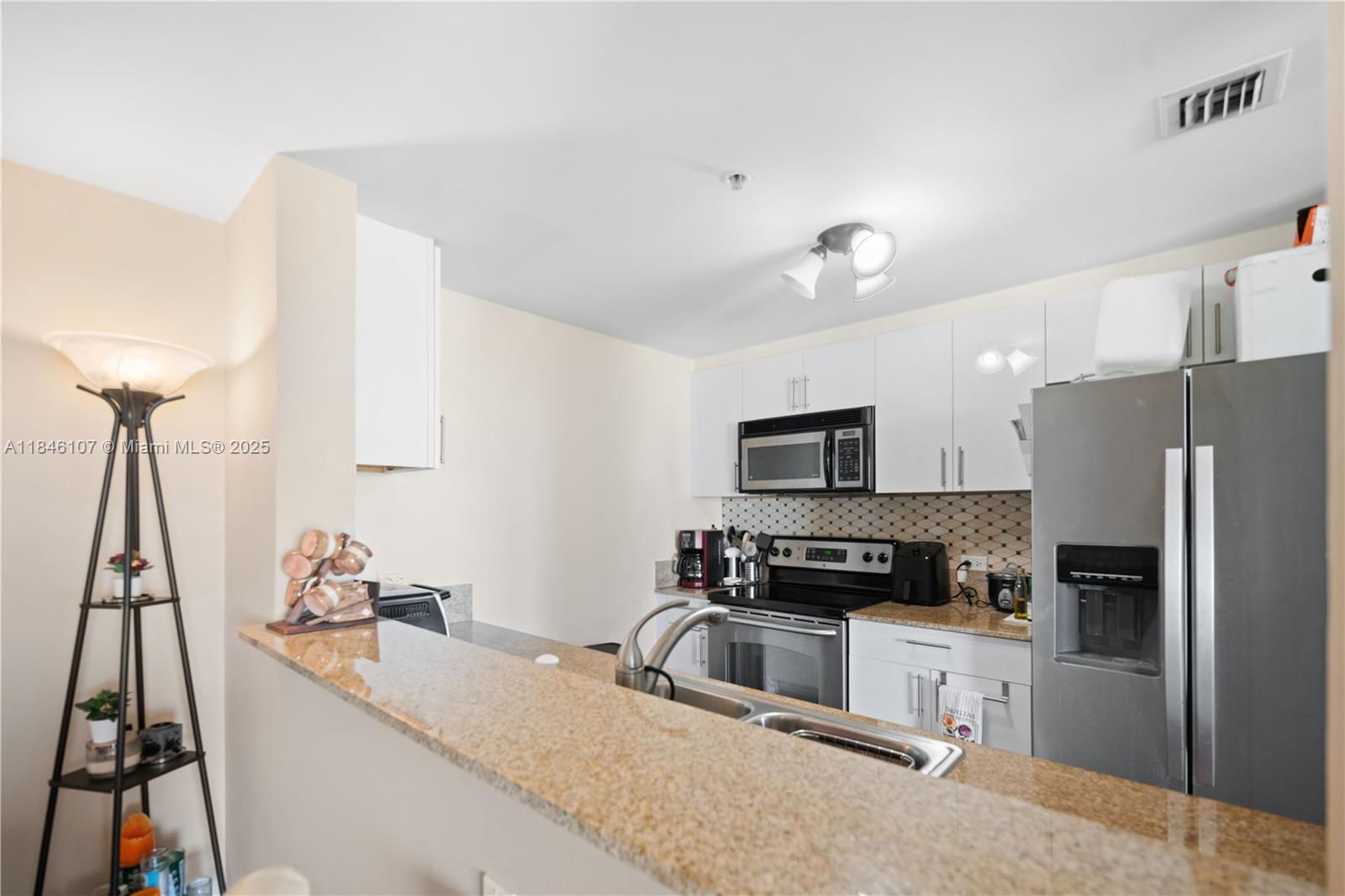 117 Northwest 42nd Avenue, Unit 1611 Miami, FL 33126 - Photo 6 of 20 a kitchen with kitchen island a counter top space appliances and a sink