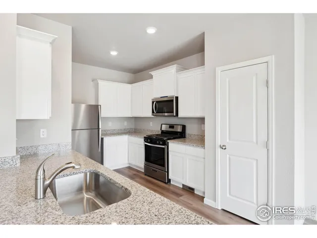 a kitchen with granite countertop a sink stainless steel appliances and cabinets