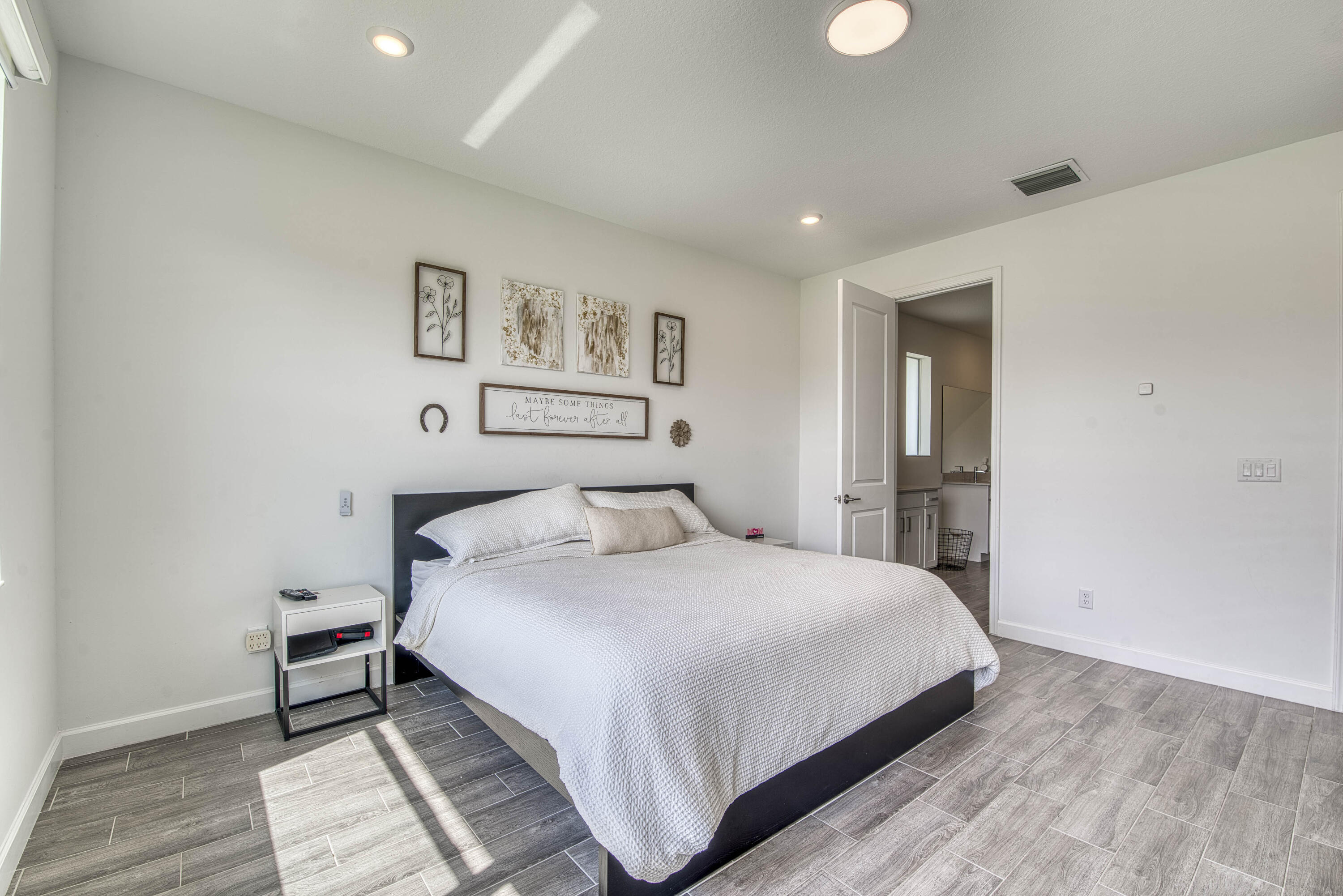 1463 Heron Nook Road Loxahatchee, FL 33470 - Photo 15 of 87 a large bedroom with a bed and wooden floor