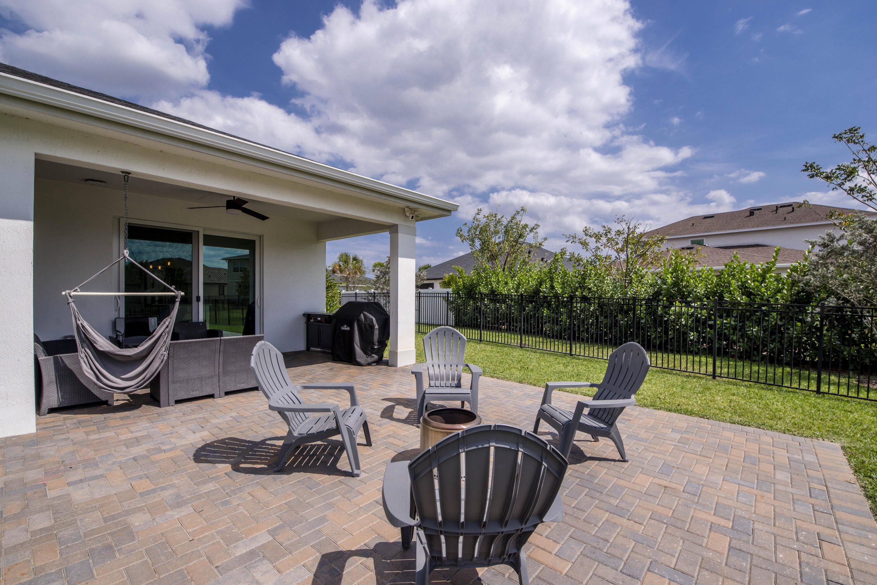1463 Heron Nook Road Loxahatchee, FL 33470 - Photo 34 of 87 a view of a patio with table and chairs potted plants with wooden fence