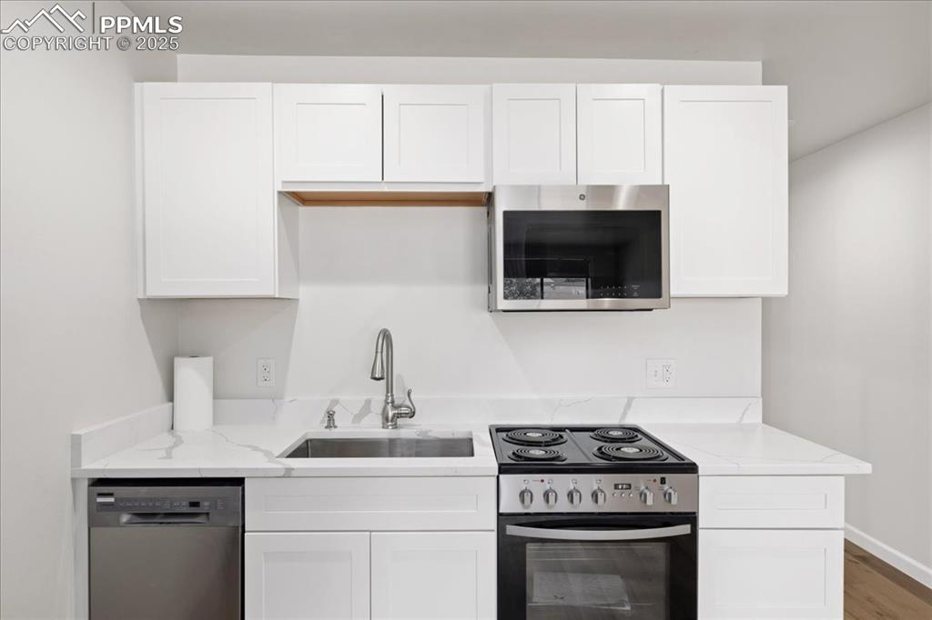 99 Granite Street, Unit 218 Frisco, CO 80443 - Photo 11 of 38 a kitchen with a stove and a white cabinet