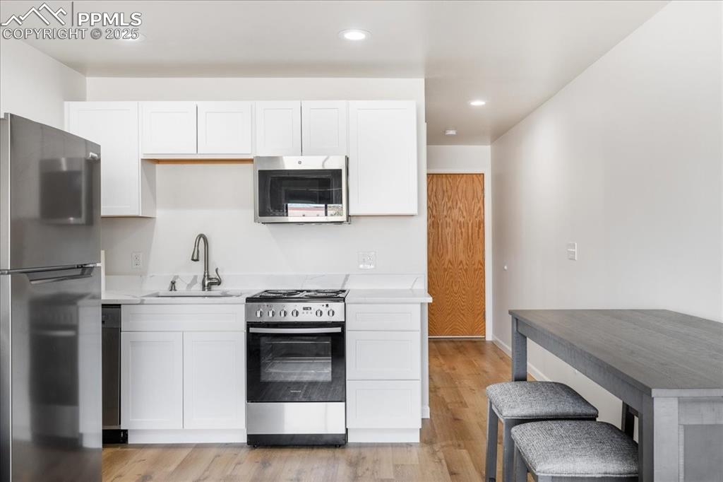 99 Granite Street, Unit 218 Frisco, CO 80443 - Photo 10 of 38 a kitchen with stainless steel appliances a stove a sink a microwave a refrigerator and cabinets
