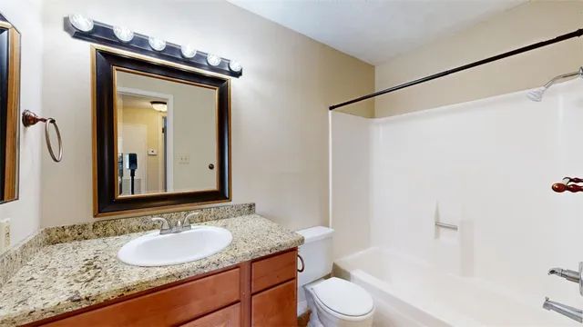 a bathroom with a granite countertop sink toilet and shower