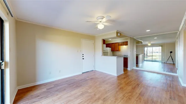 a view of a kitchen with wooden floor and a ceiling fan