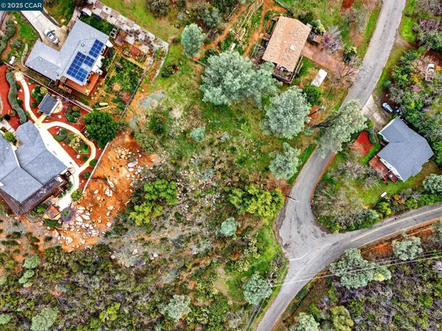 an aerial view of a house with a yard and wooden fence