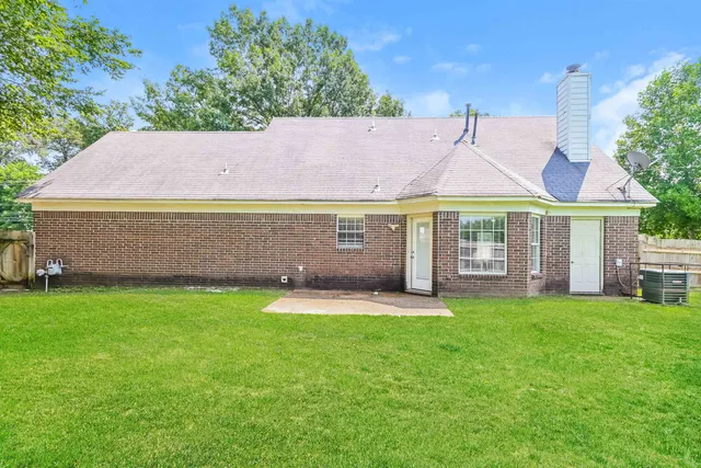 a front view of a house with a yard and trees