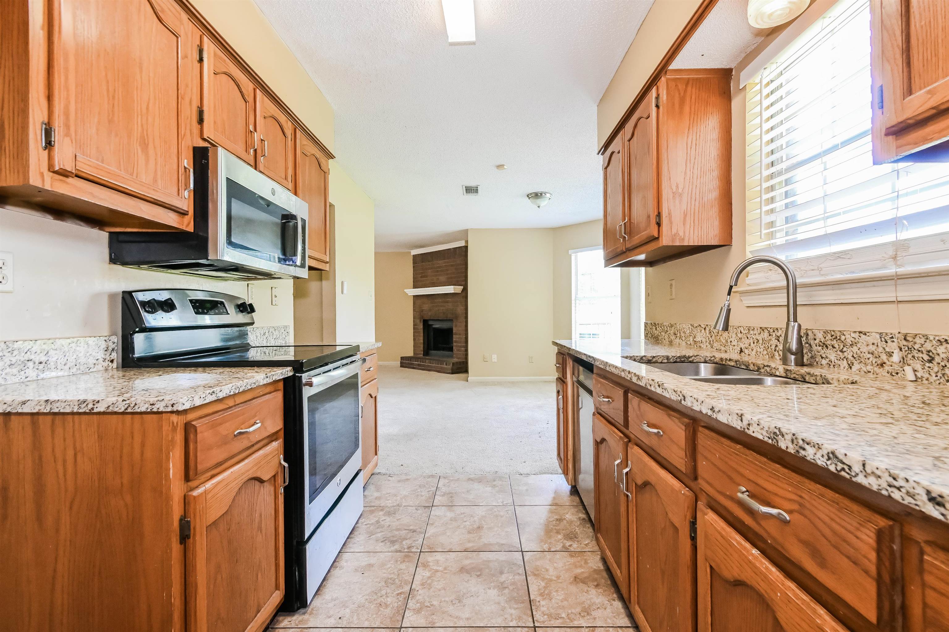 2569 Kate Bond Road Memphis, TN 38133 - Photo 7 of 17 a kitchen with stainless steel appliances granite countertop a sink stove and refrigerator