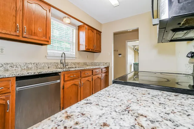 a kitchen with granite countertop a sink and a stove