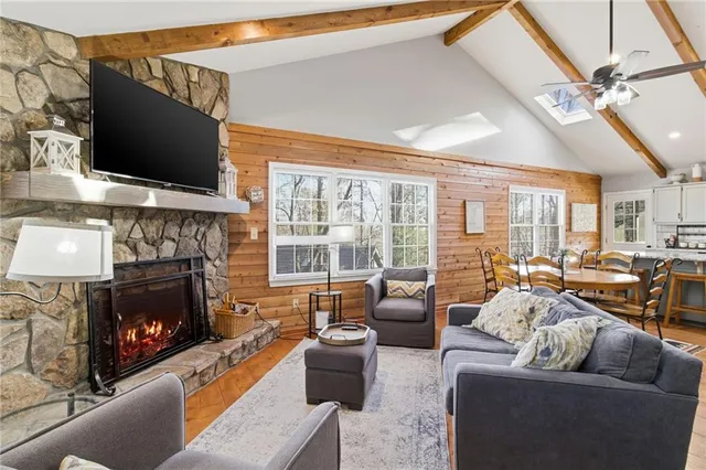 a living room with furniture a flat screen tv and a fireplace