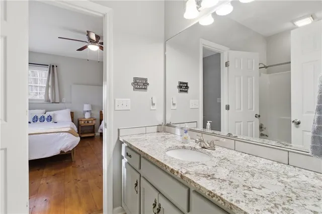 a en suite bathroom with a granite countertop sink and a mirror