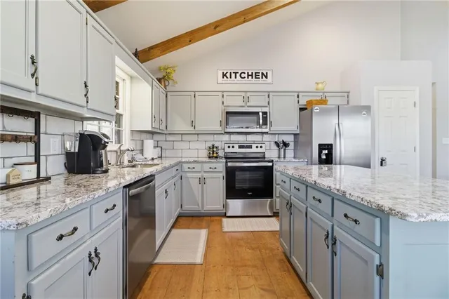 a kitchen with stainless steel appliances granite countertop a stove sink and cabinets