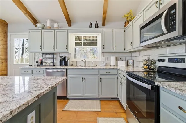 a kitchen with stainless steel appliances granite countertop a sink stove and cabinets