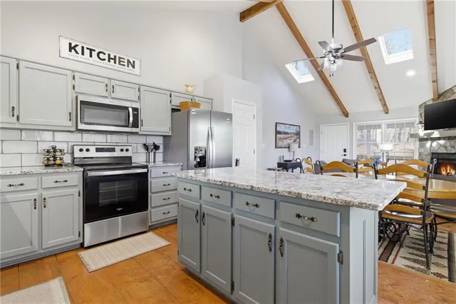 a kitchen with stainless steel appliances granite countertop a stove sink and cabinets