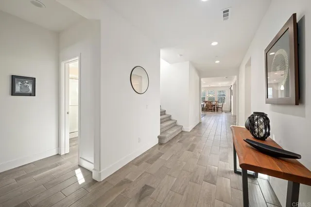 a hallway with a view of living room with furniture and wooden floor