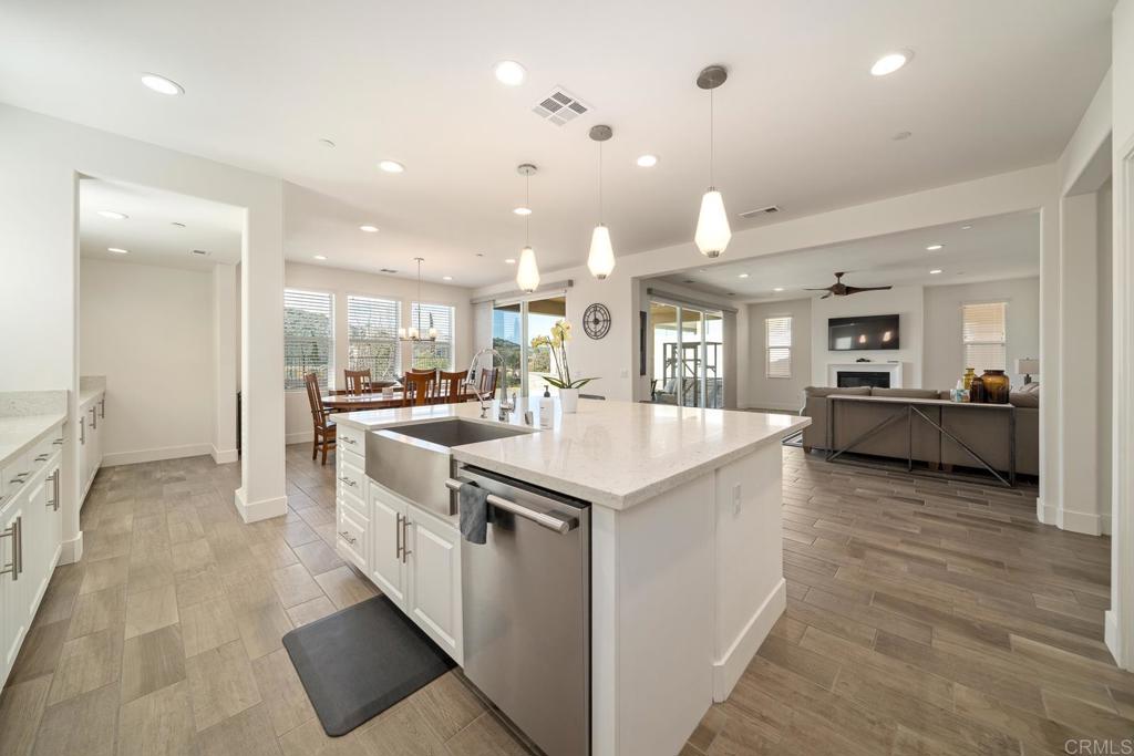 35764 Bay Morgan Lane Fallbrook, CA 92028 - Photo 10 of 69 a large kitchen with kitchen island a stove a sink a refrigerator and a dining table with wooden floor