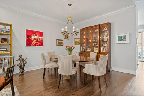a dining room with furniture a chandelier and wooden floor