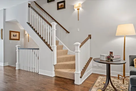 a view of staircase with lots of frames on wall and wooden floor