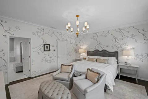 a spacious bedroom with a bed and a chandelier