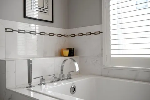 a bathroom with a tub a sink and a window