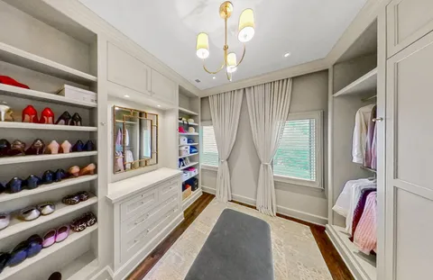 a view of walk in closet with clothes and shoes