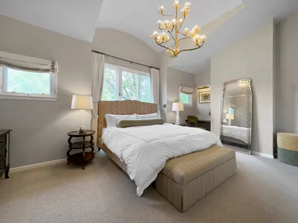 a spacious bedroom with a bed and a chandelier
