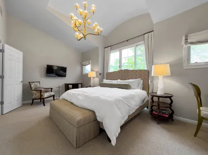 a spacious bedroom with a bed and a chandelier