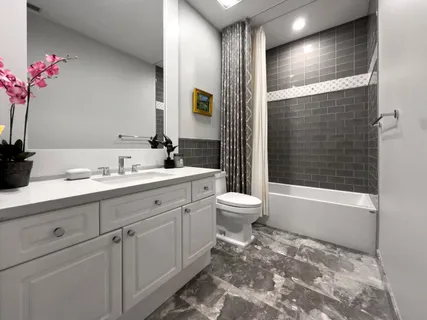 a bathroom with a bathtub sink vanity mirror and toilet
