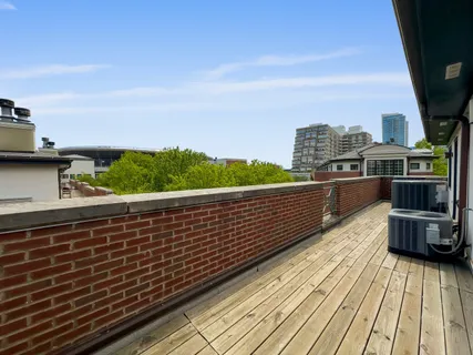 a view of city from a balcony with wooden floor