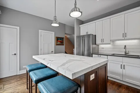 a kitchen with a table chairs refrigerator and cabinets