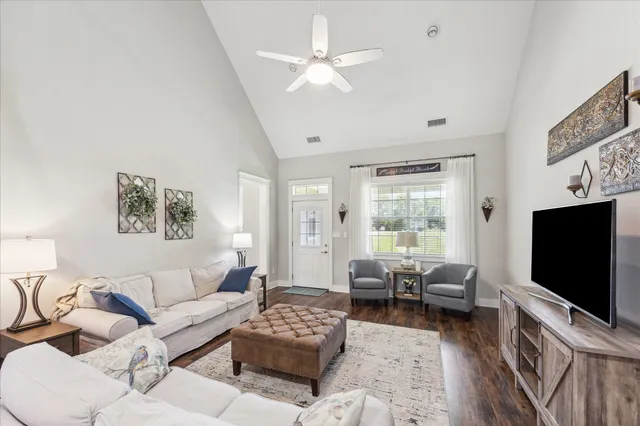 a living room with furniture a flat screen tv and a large window