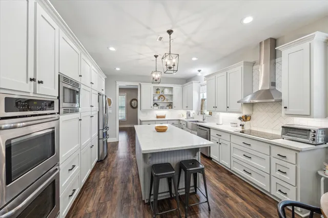 a kitchen with stainless steel appliances a white center island and a stove