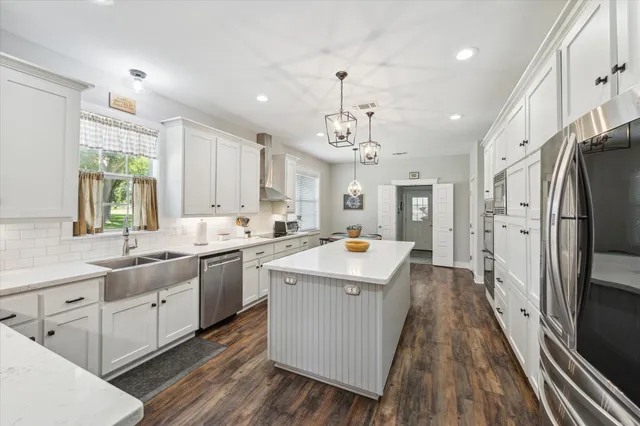 a kitchen with stainless steel appliances granite countertop a sink stove and refrigerator