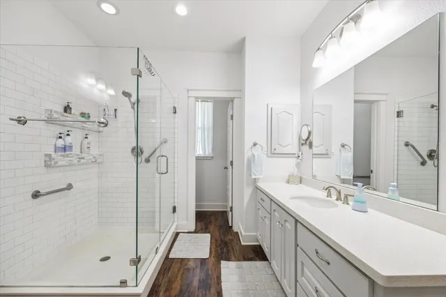 a bathroom with a double vanity sink a mirror a shower and a bathtub