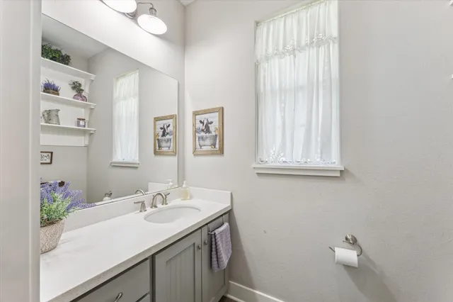 a bathroom with a sink vanity granite and a mirror