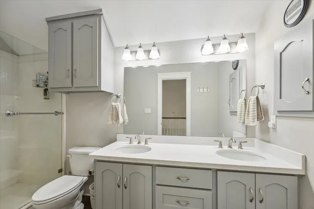 a bathroom with a sink vanity granite toilet and a mirror