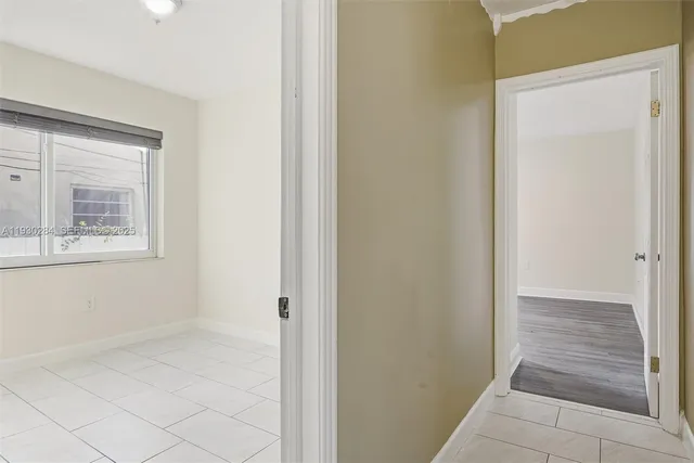 a view of a hallway with wooden floor and a door