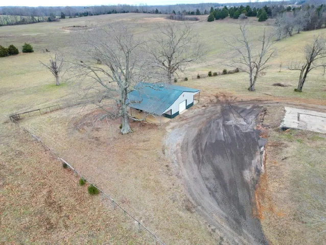 a view of a dry yard with wooden fence