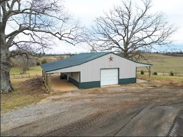a backyard of a house with large trees and covered with snow