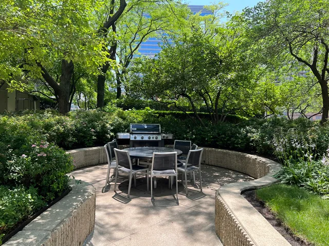 a view of a backyard with furniture and garden